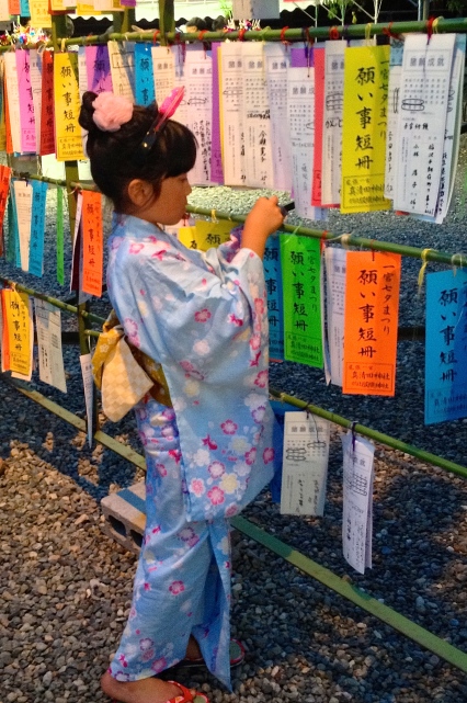 Young girl in her Yuakata placing her Tanzaku (wish)
